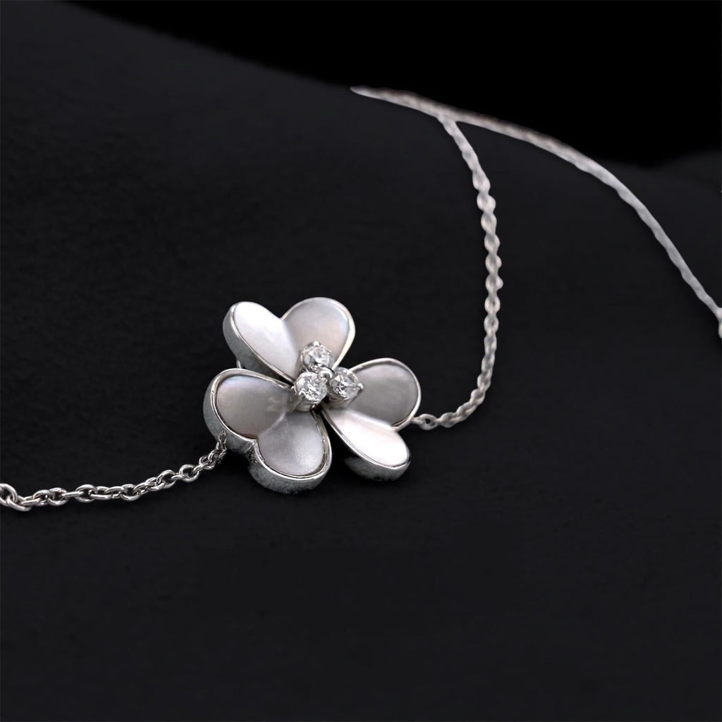 Impimo mother of pearl and moissanite flower pendant necklace - tight macro of the flower pendant filling the frame with the chain running through it.