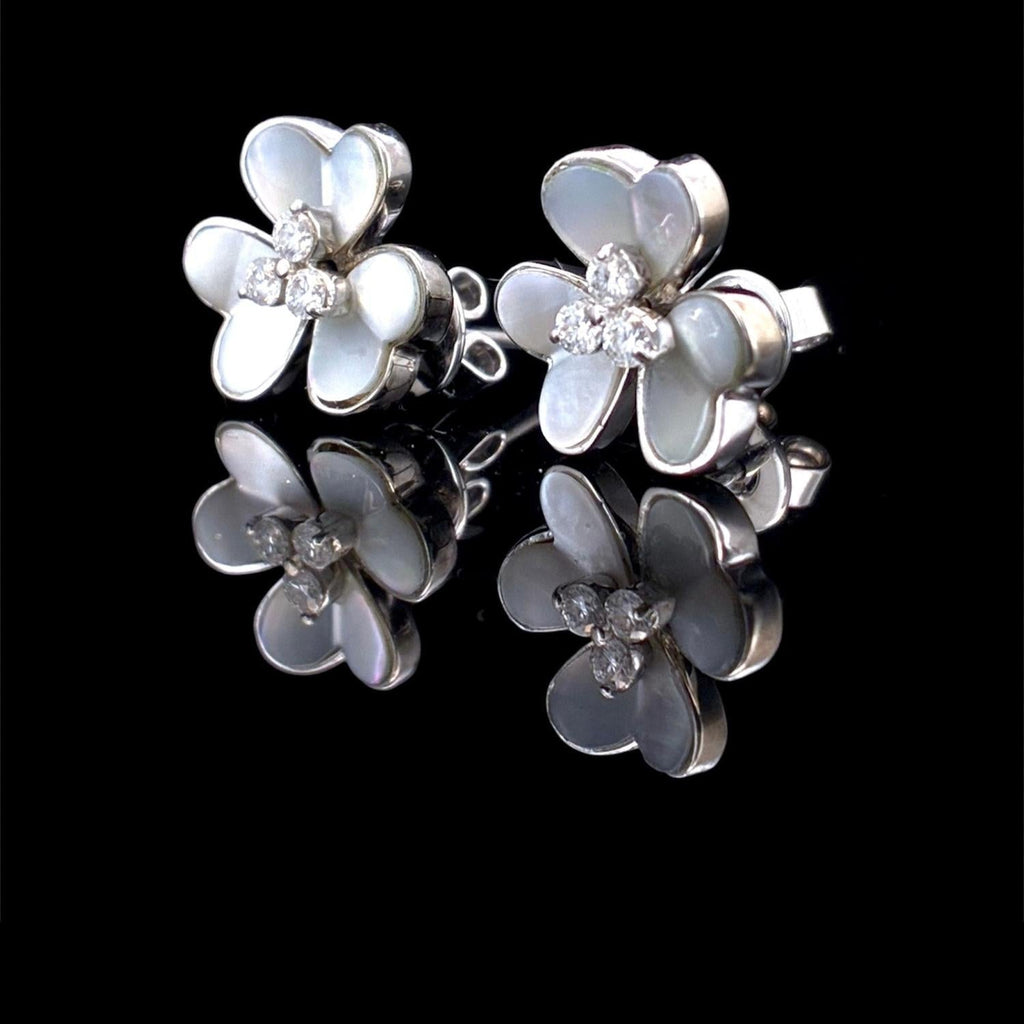 Impimo mother of pearl and moissanite flower stud earrings - the pair shown front on, four-petal shell flowers with moissanite centres on white metal.