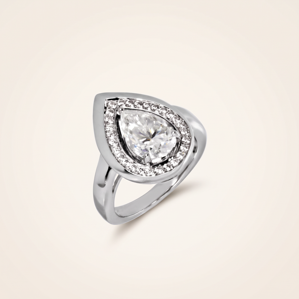 3 CT moissanite pear cut ring in 925 sterling silver with 18K white gold plating, on a light ivory background