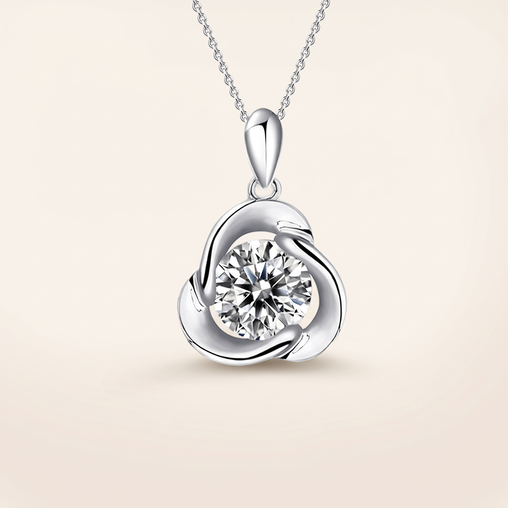 1 CT moissanite round cut pendant in 925 sterling silver with 18K white gold plating, on a light ivory background
