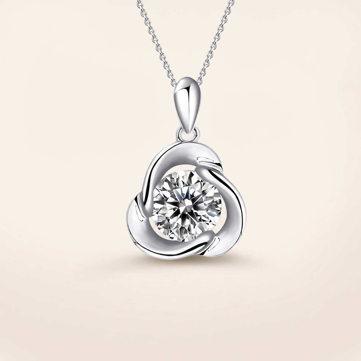 1 CT moissanite round cut pendant in 925 sterling silver with 18K white gold plating, on a light ivory background