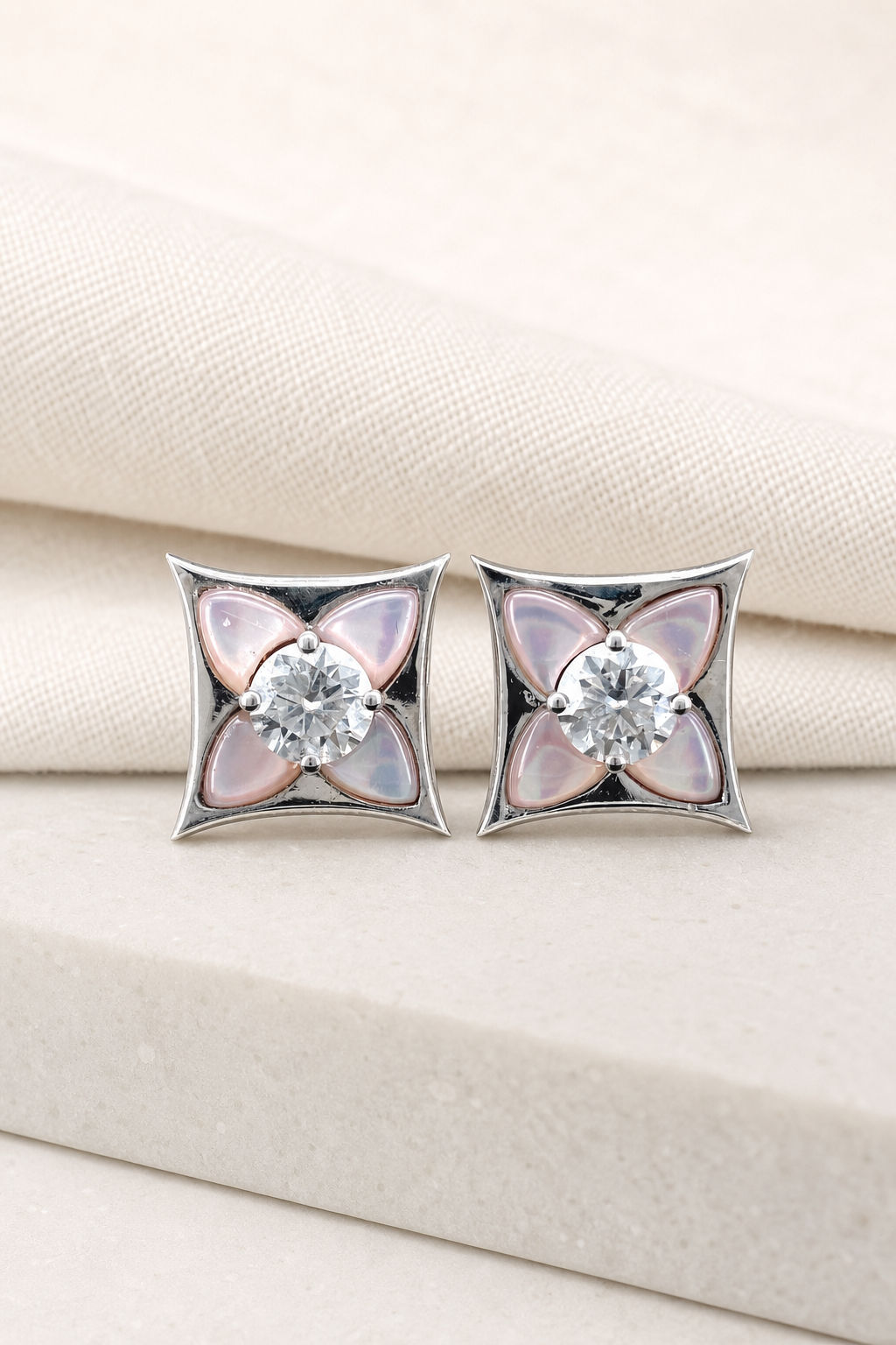 Impimo Natural Pink Mother of Pearl & Moissanite Four-Point Star Stud Earrings - 925 Sterling Silver with 18K White Gold Plating | display view on ivory linen