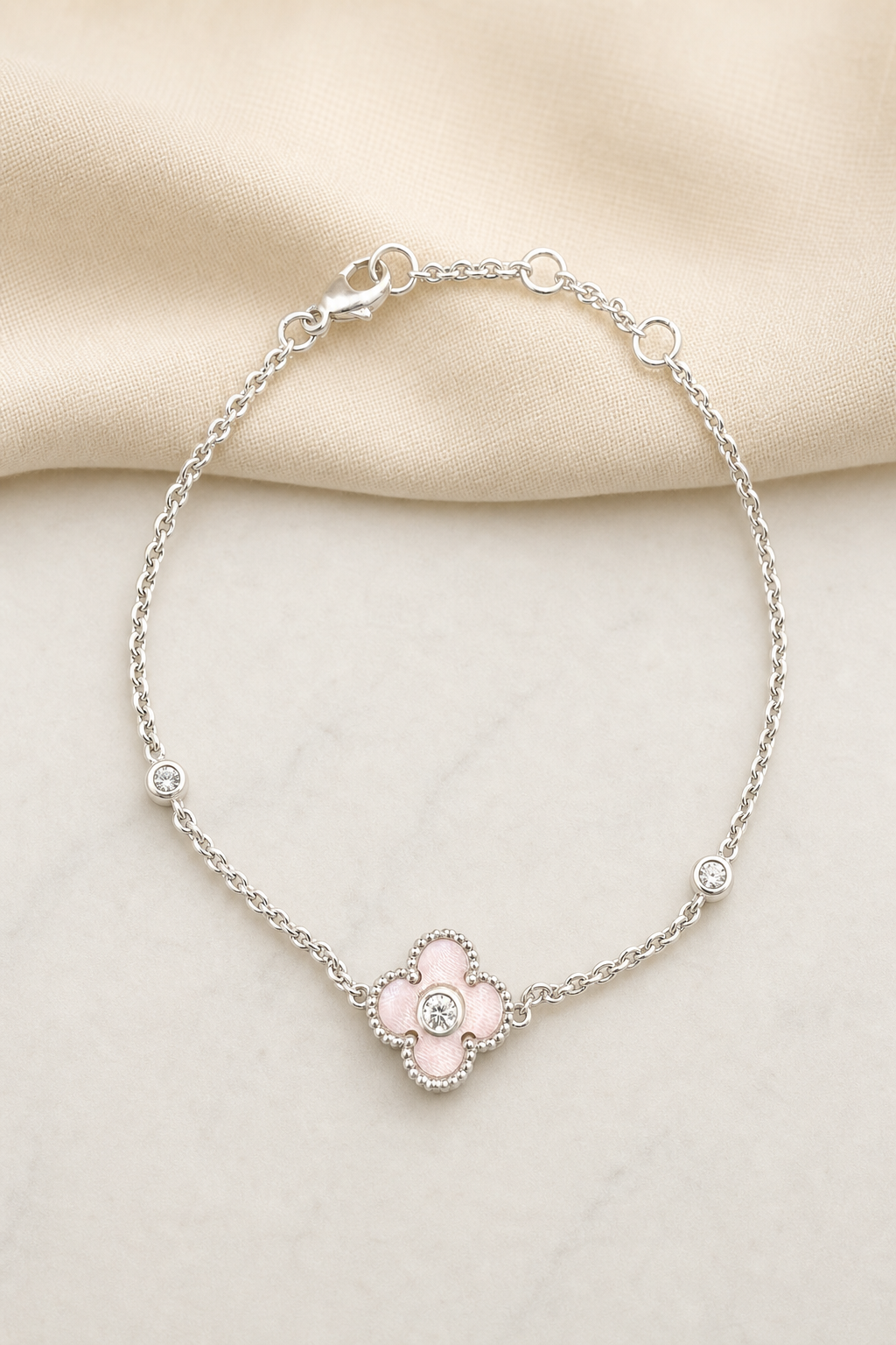 Impimo Natural Pink Mother of Pearl & Moissanite Four-Leaf Clover Bracelet - 925 Sterling Silver with 18K White Gold Plating | display view on ivory linen