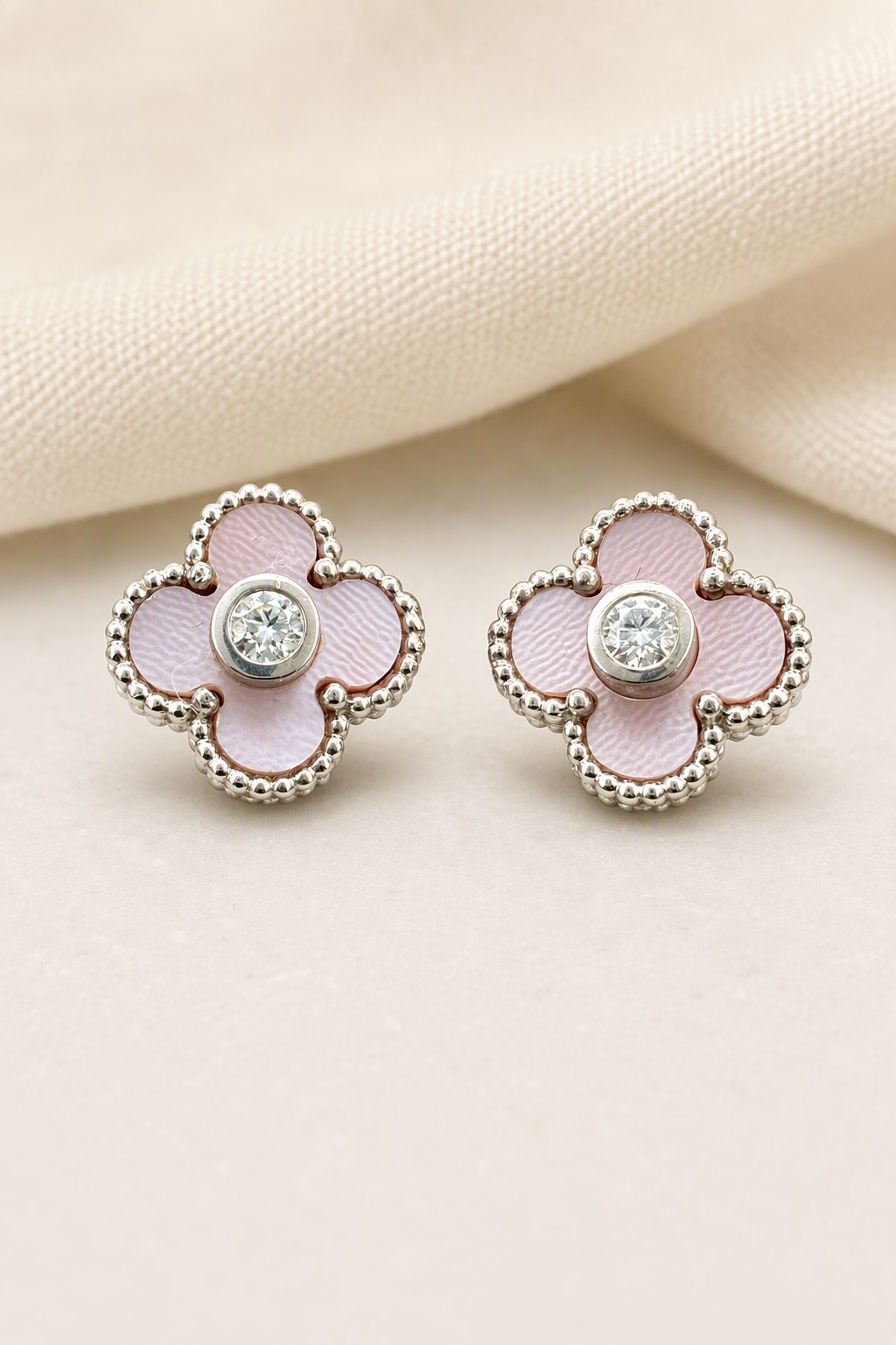 Impimo Natural Pink Mother of Pearl & Moissanite Four-Leaf Clover Stud Earrings - 925 Sterling Silver with 18K White Gold Plating | display view on ivory linen