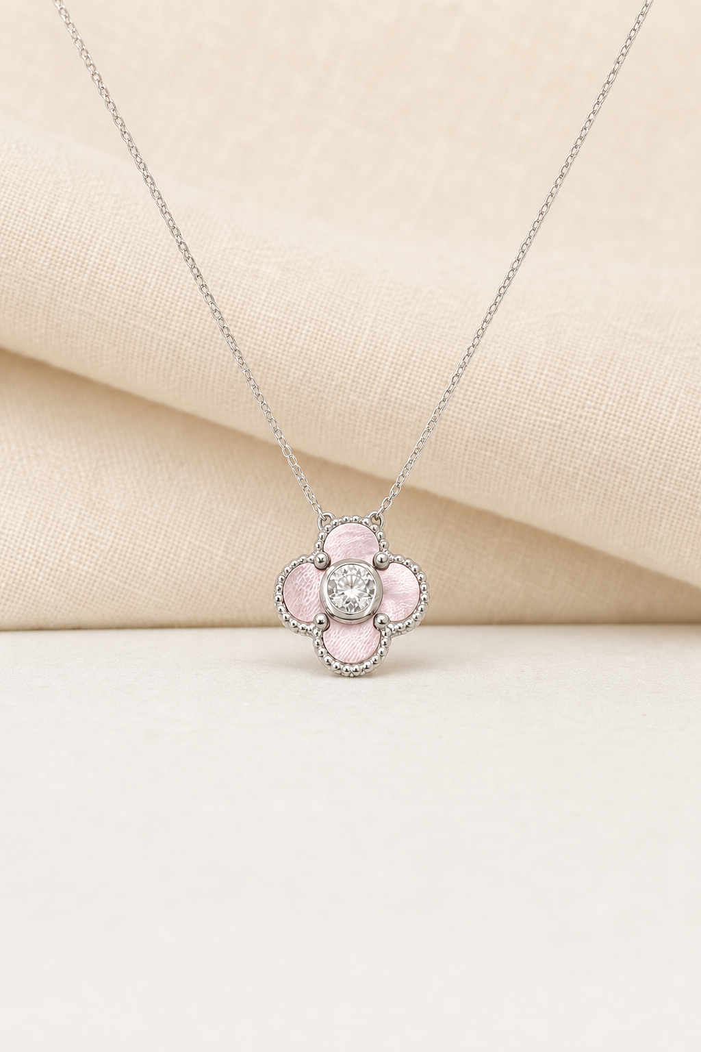Impimo Natural Pink Mother of Pearl & Moissanite Four-Leaf Clover Pendant - 925 Sterling Silver with 18K White Gold Plating | display view on ivory linen