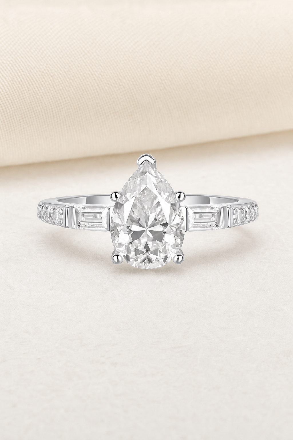 Impimo Moissanite 1.5 CT Pear Cut Ring - 925 Sterling Silver with 18K White Gold Plating | display view on ivory linen