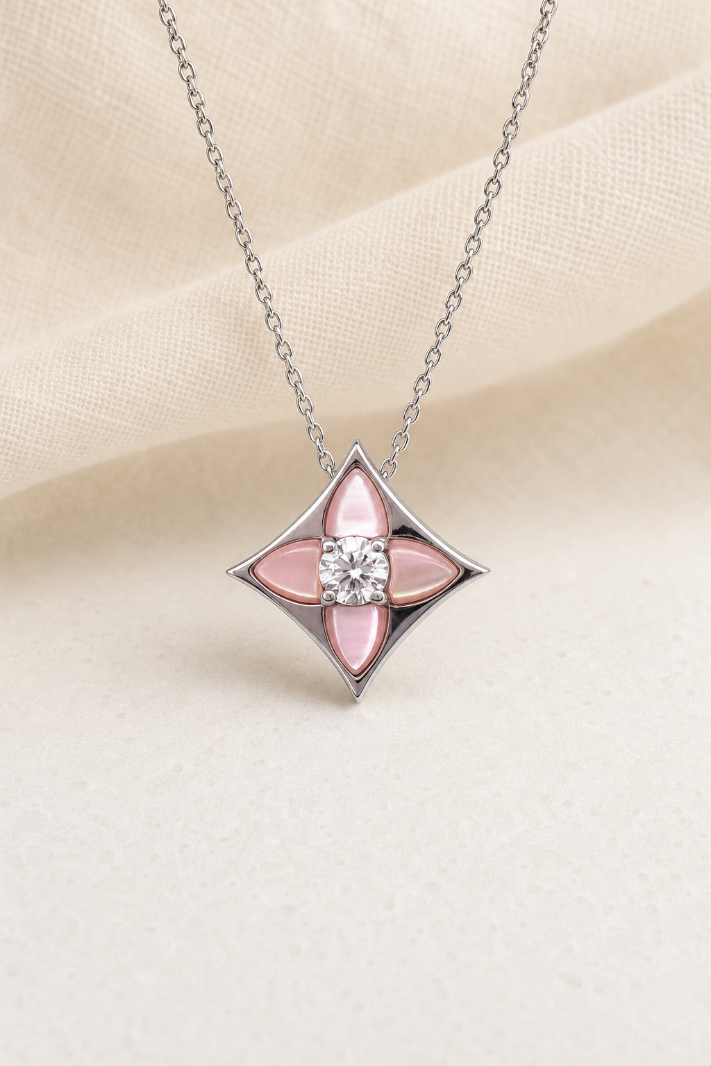 Impimo Natural Pink Mother of Pearl & Moissanite Pendant - Four-Point Star - 925 Sterling Silver with 18K White Gold Plating | display view on ivory linen