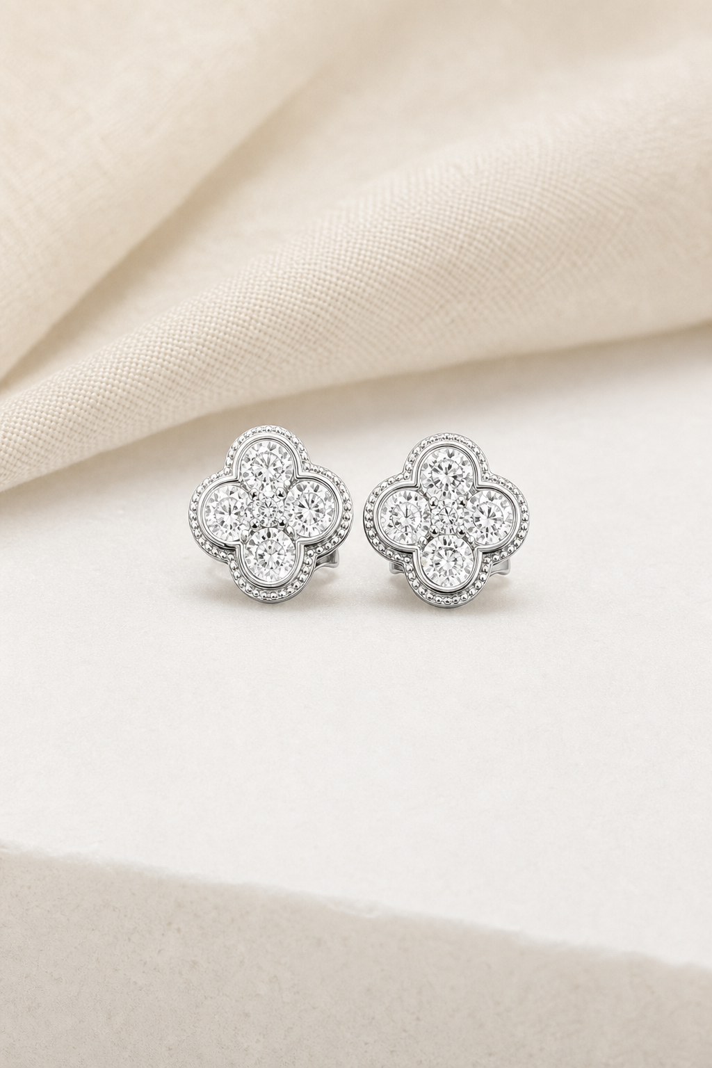 Impimo 1.9 CT (Pair) Moissanite Round Cut Earrings - 925 Sterling Silver with 18K White Gold Plating | display view on ivory linen