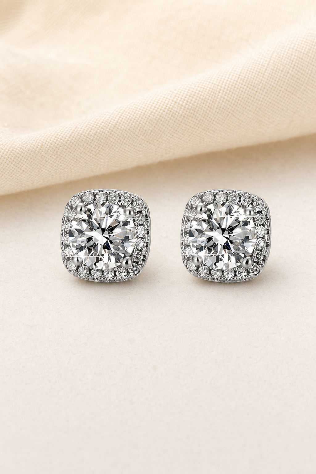 Impimo 1/2 CT (Pair) Moissanite Round Cut Earrings - Cushion Halo Stud - 925 Sterling Silver with 18K White Gold Plating | display view on ivory linen