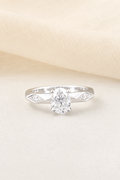 Impimo 1-2 CT Moissanite Oval Solitaire Ring with 0.20 CT Shoulder Stones - 925 Sterling Silver 18K White Gold | display view on ivory linen