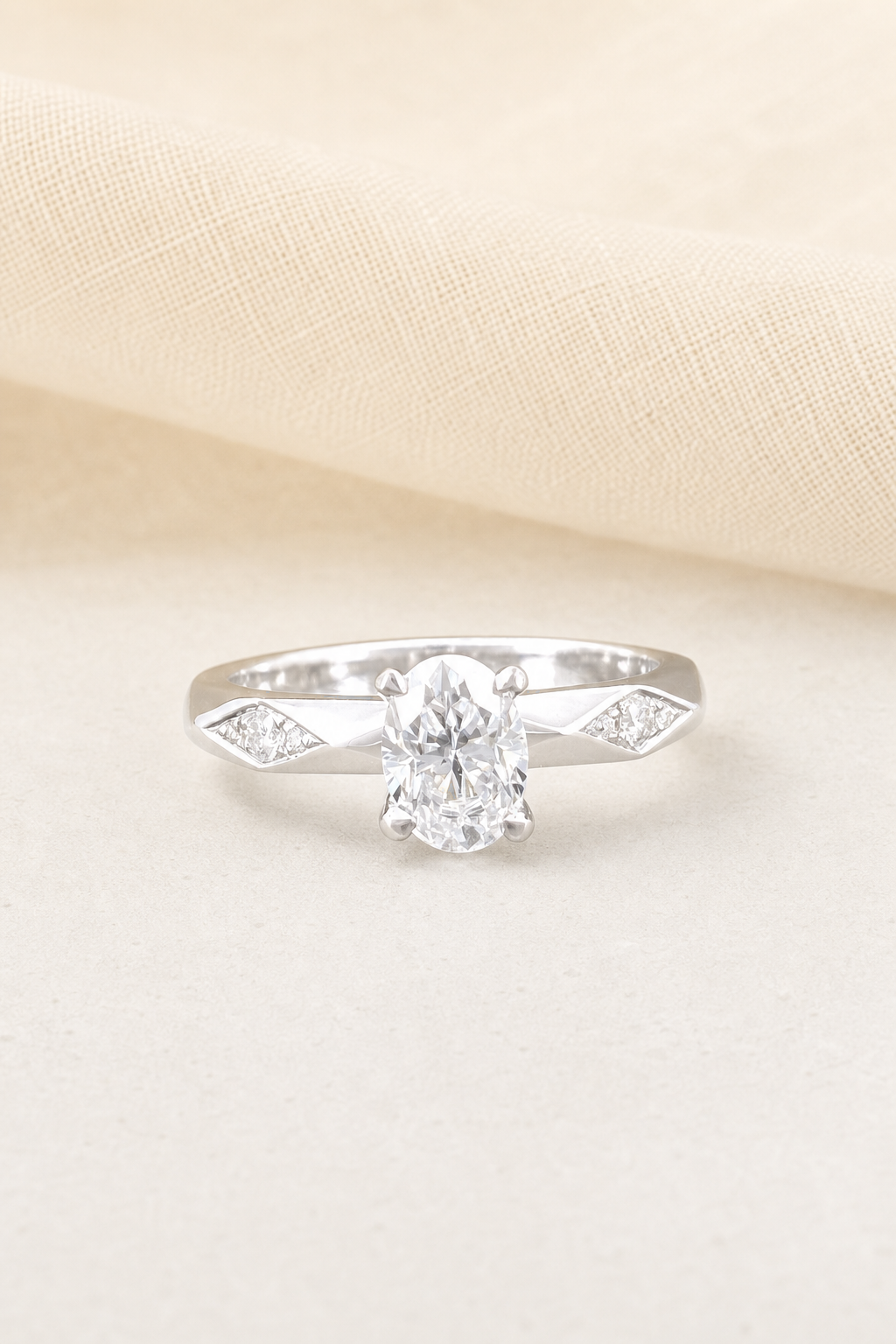 Impimo 1-2 CT Moissanite Oval Solitaire Ring with 0.20 CT Shoulder Stones - 925 Sterling Silver 18K White Gold | display view on ivory linen