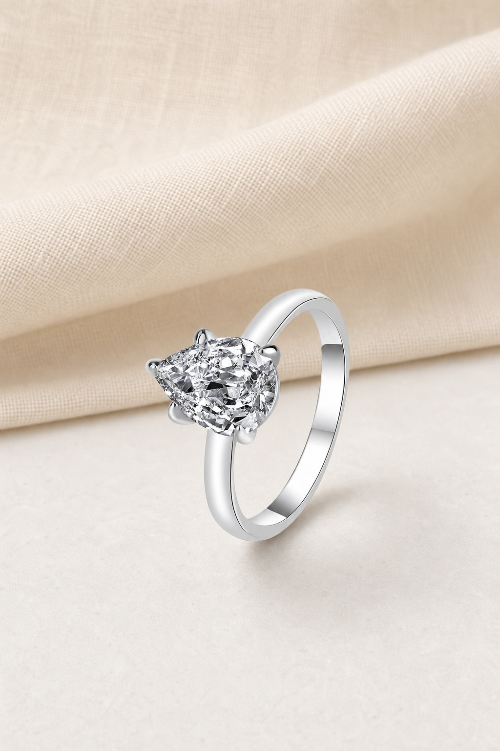 Impimo 1/2 CT Moissanite Multiple Shape Ring - 925 Sterling Silver with 18K White Gold Plating | display view on ivory linen - pear cut