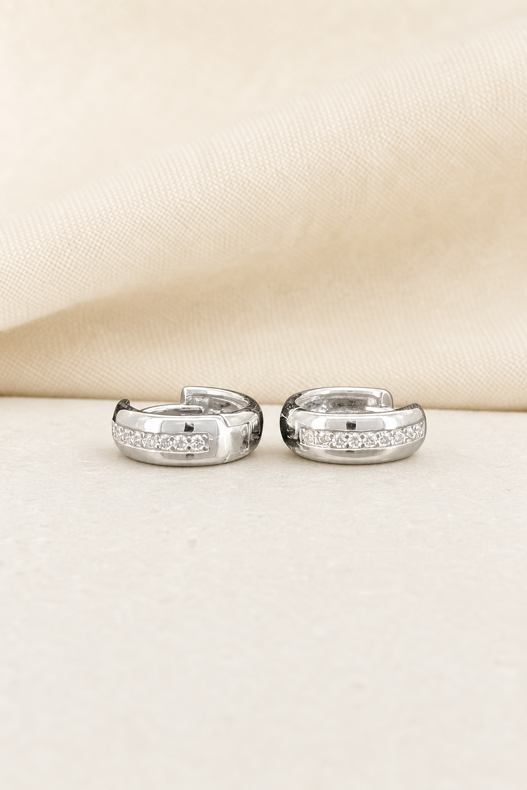 Impimo 0.2 CT (Pair) Moissanite Round Cut Earrings - 925 Sterling Silver with 18K White Gold Plating | display view on ivory linen