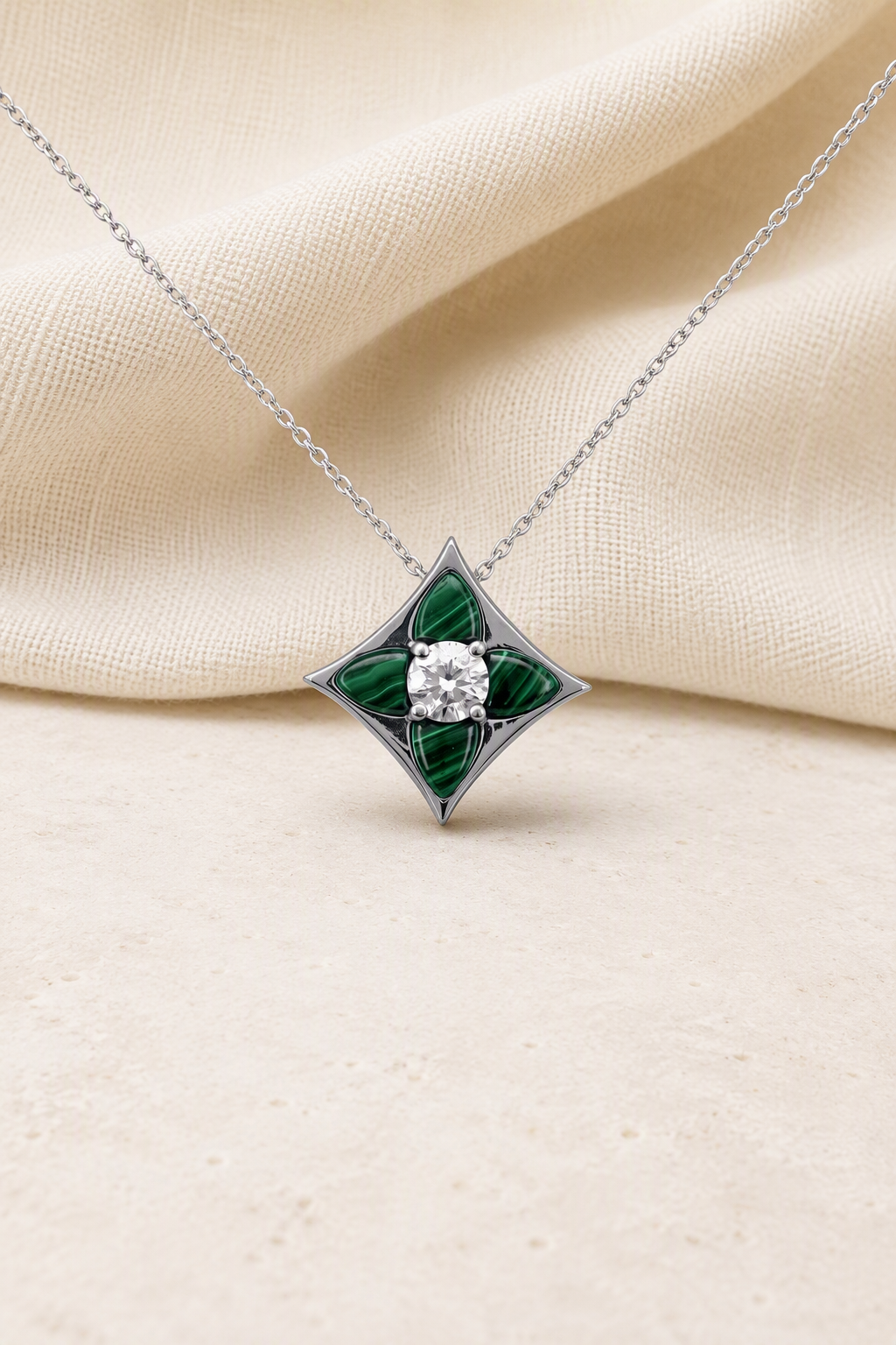 Impimo Natural Malachite & Moissanite Pendant - Four-Point Star - 925 Sterling Silver with 18K White Gold Plating | display view on ivory linen