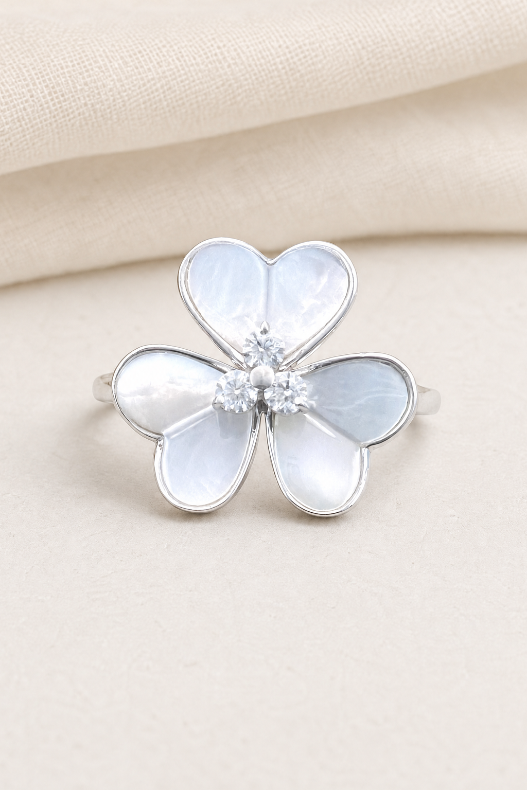 Impimo 0.15 CT Moissanite & Mother of Pearl Flower Ring - 925 Sterling Silver with 18K White Gold Plating - display view on ivory linen